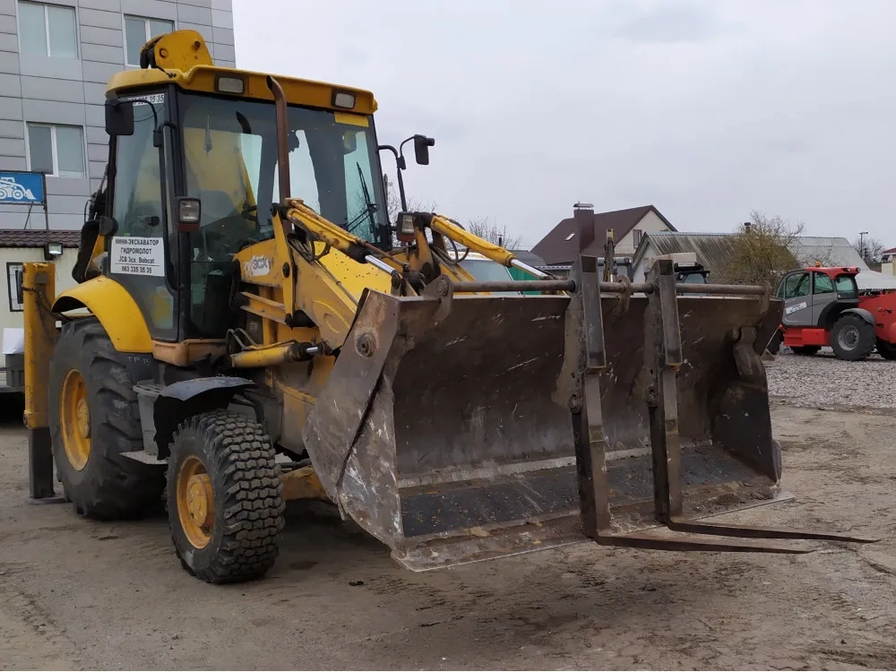 JCB з ковшем. Копання та планування