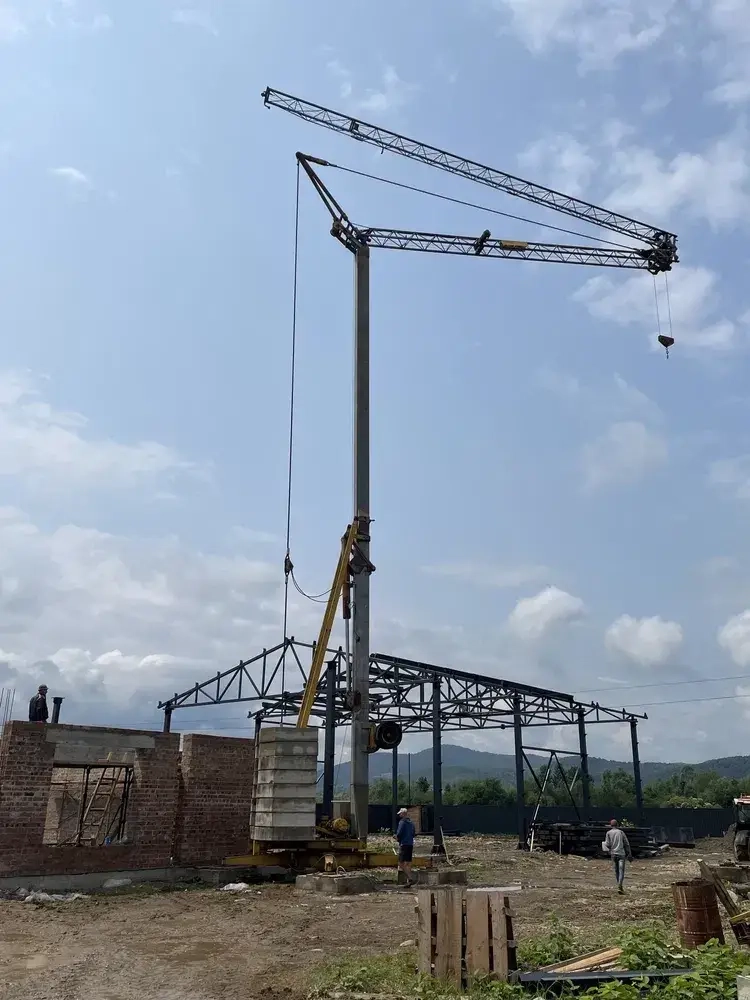 Будівельний баштовий кран для підйому важких будівельних матеріалів.