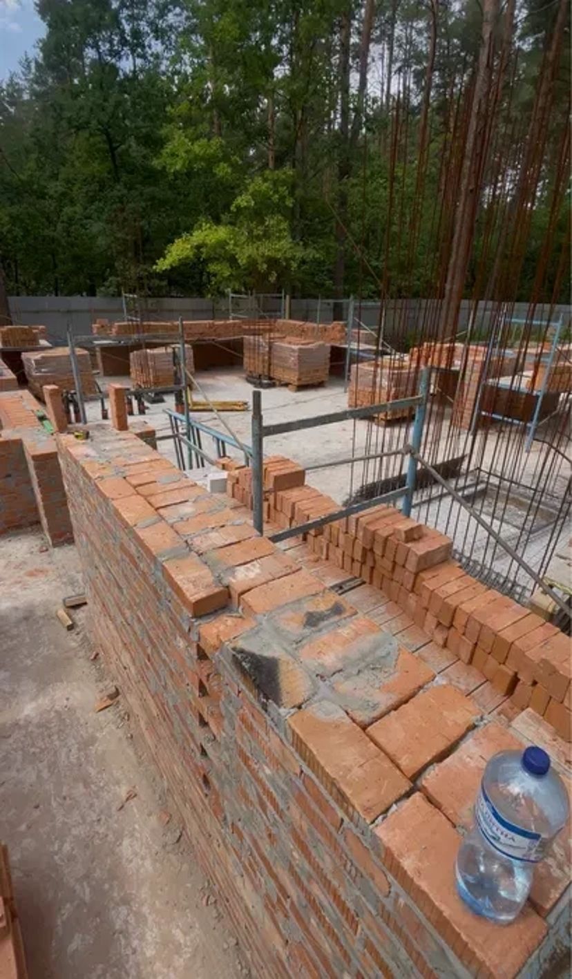 Мурування цегли. Бригада будівельників. Будівництво будинків.