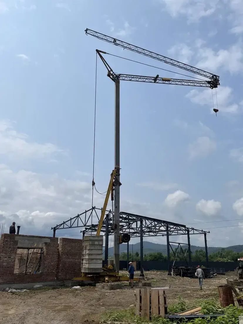 Будівельний баштовий кран для підйому важких будівельних матеріалів.