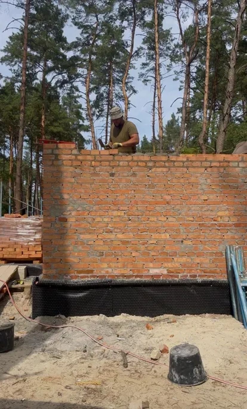 Мурування цегли. Бригада будівельників. Будівництво будинків.